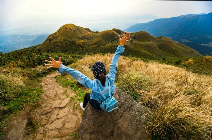 Traveler enjoying the view at the peak of Mt Qixing, the tallest mountain near Taipei