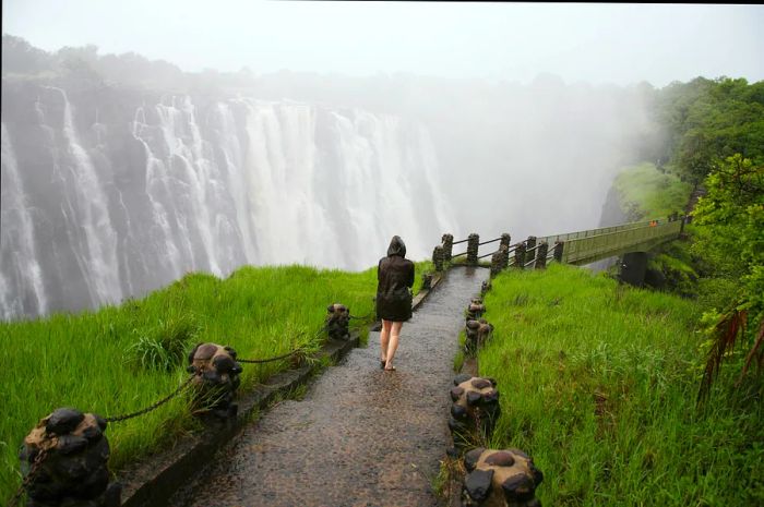 A woman approaches the footbridge at Victoria Falls, also known as Mosi-oa-Tunya (the Smoke that Thunders), in Livingstone, Zambia