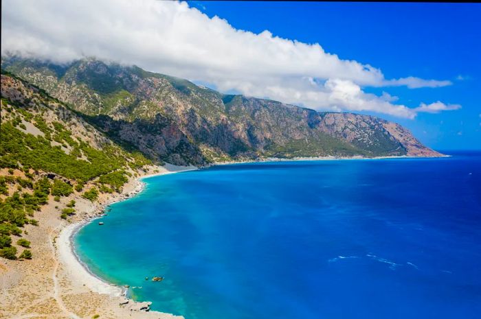 Aerial view of clouds hovering over towering mountains along the coastline, Agia Roumeli, Crete, Greece