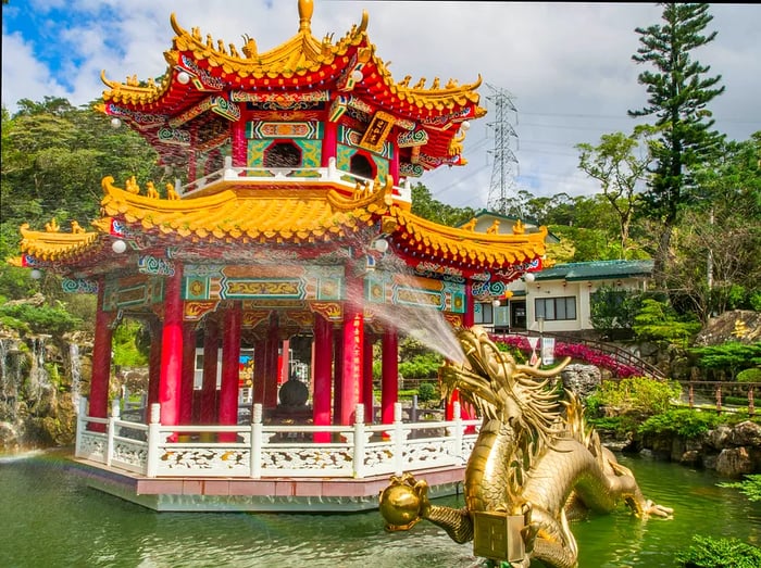 A vibrant pagoda and a gold dragon fountain spouting water near Zhinan Temple Station of the Maokong Gondola in Taipei, Taiwan.