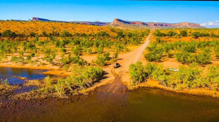 A van traversing the remote Pentecost River Crossing along Gibb River Road.