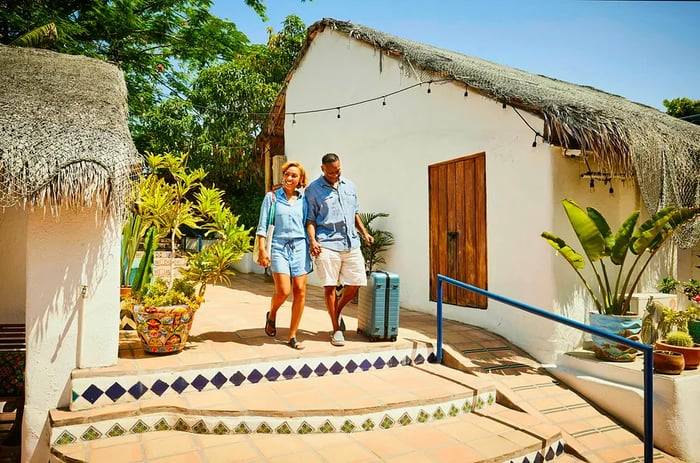 A couple strolling hand in hand through a resort village in Mexico.