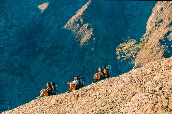 Hikers traverse a ridge in the Fish River Canyon, Namibia.