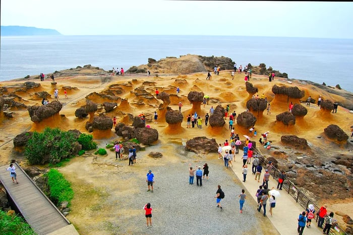 An aerial view of tourists observing the uniquely shaped rocks, sculpted by ocean erosion, at Yehliu Geopark, Taiwan.