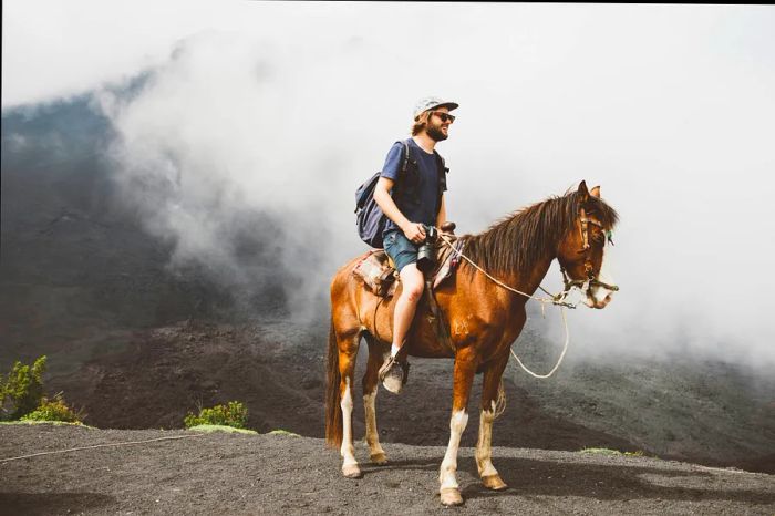 A young man rides a horse at Pacaya volcano near Antigua, Guatemala.