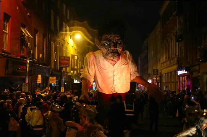 A massive, monstrous effigy makes its way through the streets of Dublin during the Bram Stoker Festival, captivating a large audience.