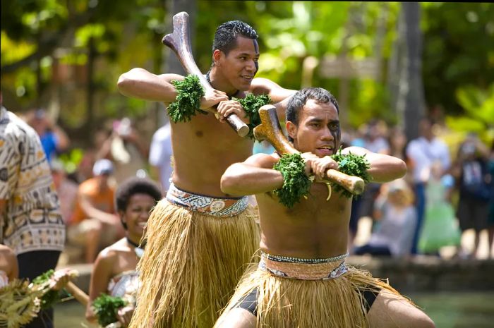 Fijian students perform traditional dances aboard a canoe.