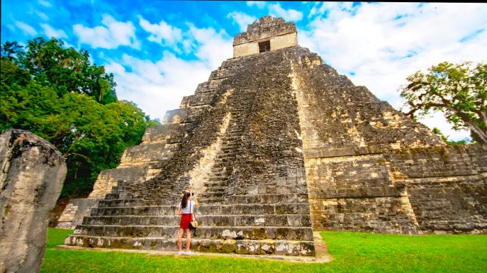 Teenager taking photos with a mobile phone at Tikal in Guatemala.