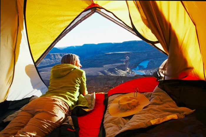 A woman relaxing inside a tent at Horse Shoe Bend, Fish River Canyon, Namibia