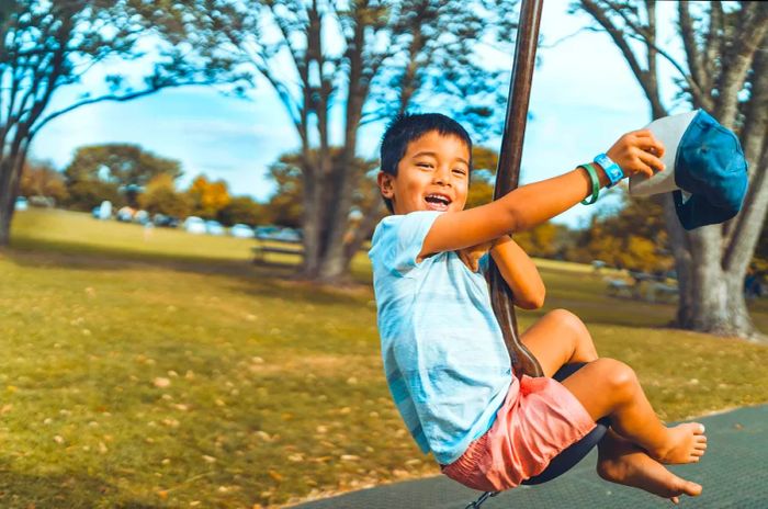 A happy child enjoying a flying fox ride at a playground in Auckland, New Zealand.