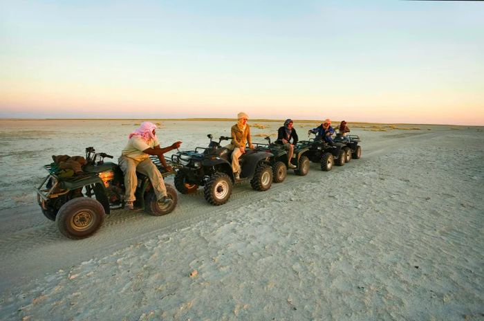 Tourists navigate Botswana's salt flats on quad bikes