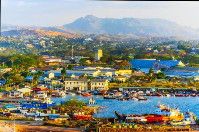 A bird's-eye view of Lautoka, Fiji, showcasing buildings and a harbor with mountains in the backdrop