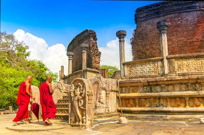 Two barefoot monks approach the ruins of a temple