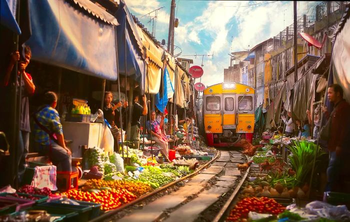 The train from Bangkok arriving at Samut Sakhon Railway Market