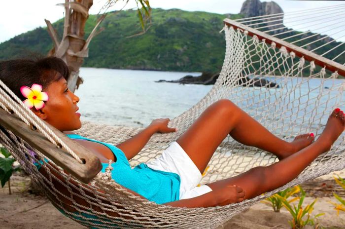 A woman lounging in a hammock on Kuata Island, Fiji.