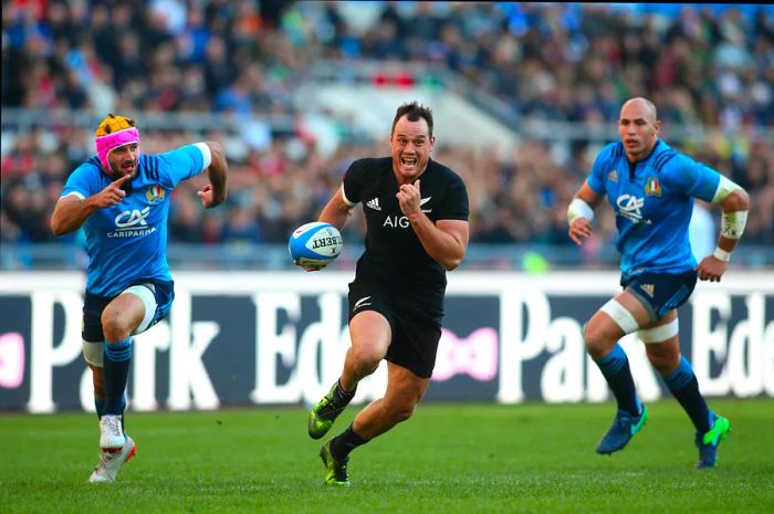 Rugby players compete during a test match between Italy and New Zealand.