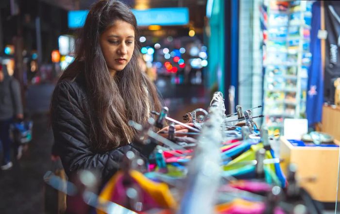 Young woman browsing for clothes at a night market