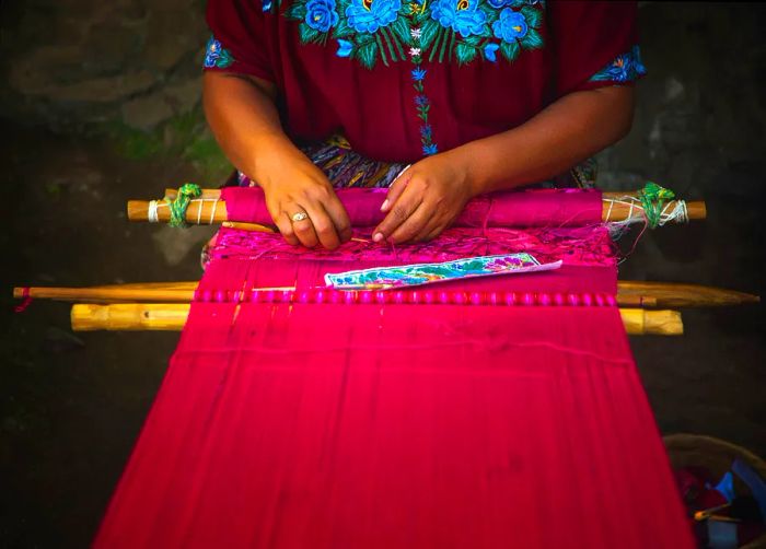 A Guatemalan Maya woman weaving on a backstrap loom