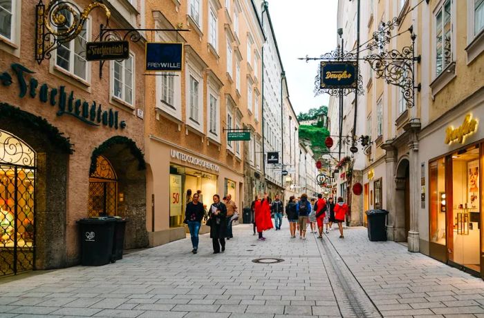 Shoppers stroll past stores in Getreidegasse, Salzburg, Austria