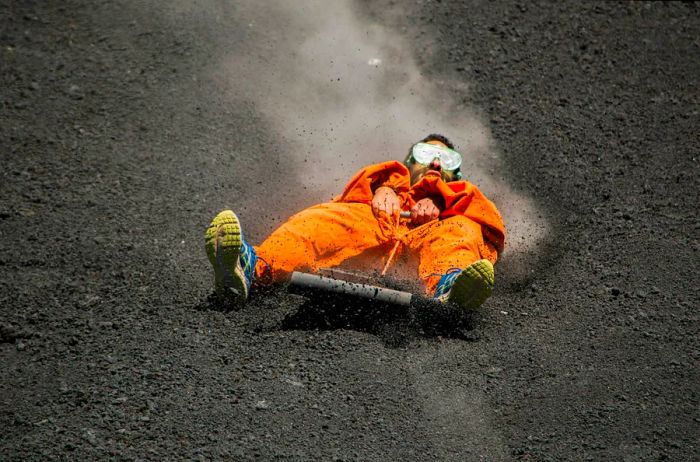 A person experiencing volcano boarding at Cerro Negro in Nicaragua