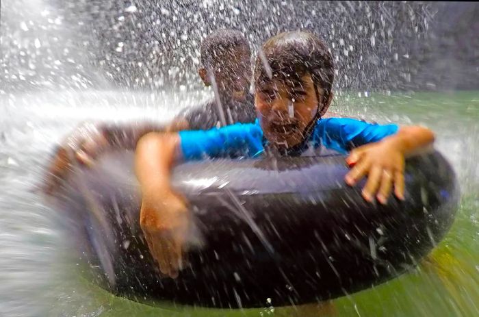 Joyful children playing under a waterfall