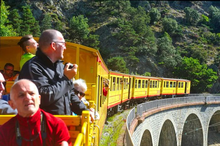 Passengers aboard the Little Yellow Train in the Pyrenees, France