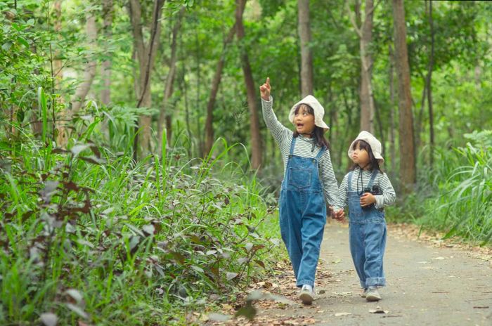 Children are making their way to the family campsite nestled in the forest along a scenic trail.