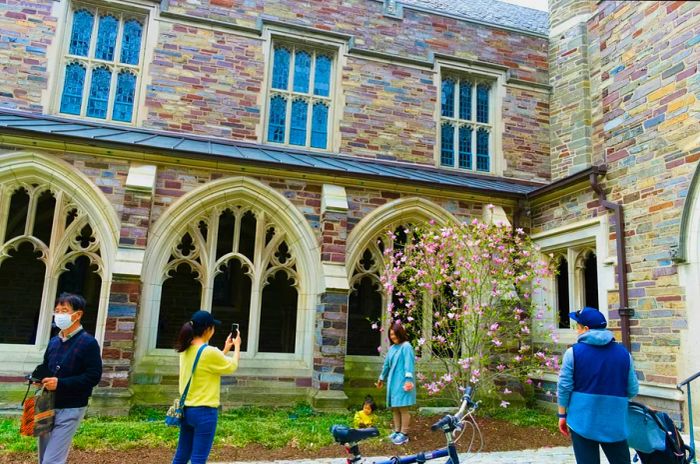 Tourists capture memories at one of Princeton University's picturesque buildings.