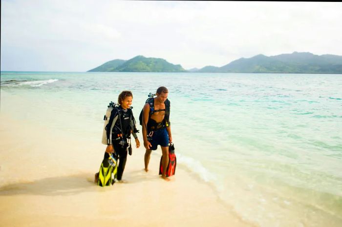 A young Fijian couple strolls along the beach on Picnic Island