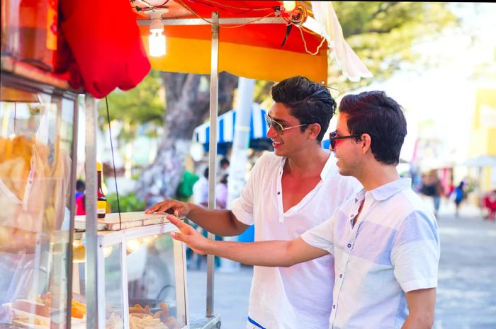 Two men buying food at a food truck in Mexico