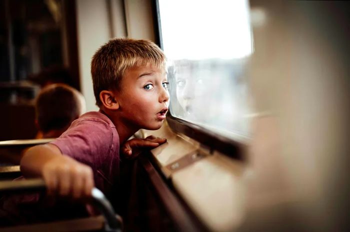 A young boy gazes out the window of a train in Chicago, USA.