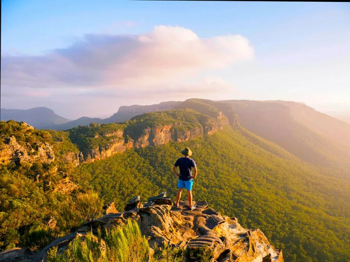 A man stands atop a peak in the Blue Mountains, New South Wales, Australia