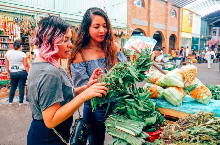 GettyImages-638344728.jpgTwo friends examining vegetables at an open-air market in Mexico City