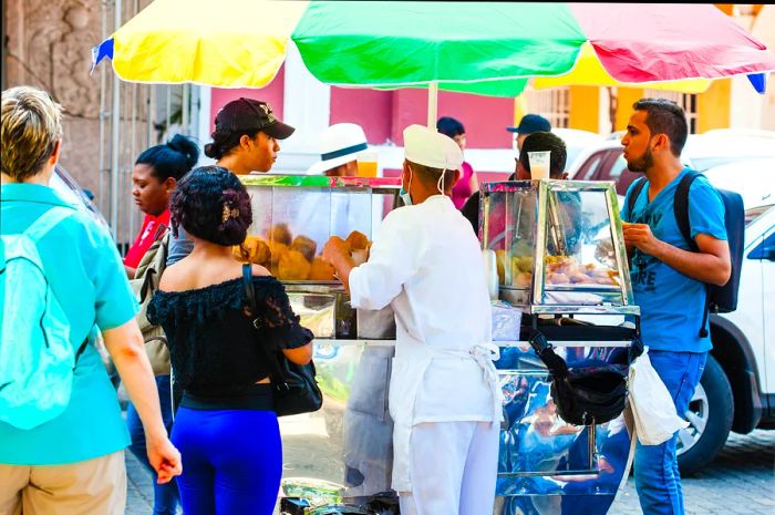 A woman selling fried street food at a stall in Cartagena