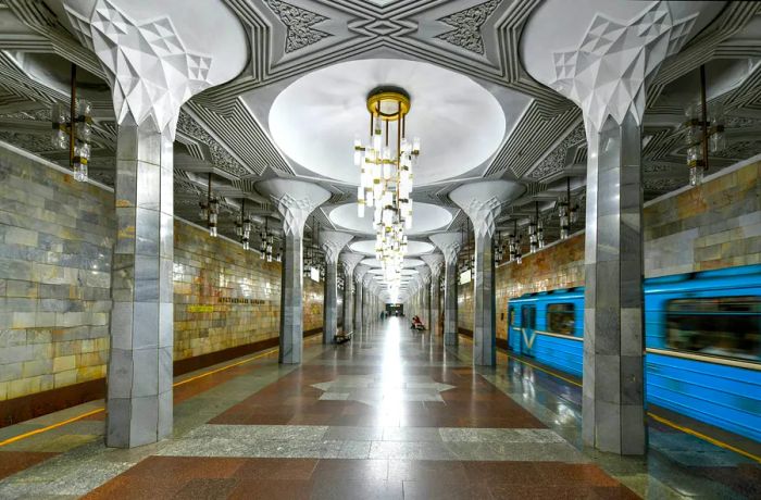 A central area in an underground station featuring large decorative light fixtures hanging down