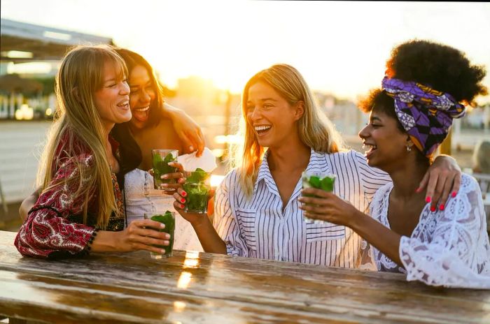 Joyful girls enjoying cocktails at a beachside bar