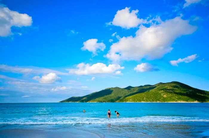 Visitors enjoy swimming in the crystal-clear Atlantic waters at Prainha Beach, located near Rio de Janeiro, Brazil.