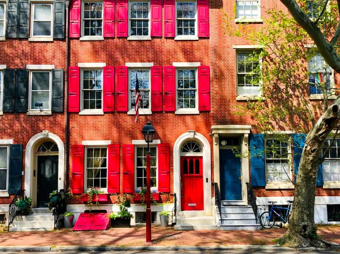 A picturesque row of large terraced red-brick homes lining a street