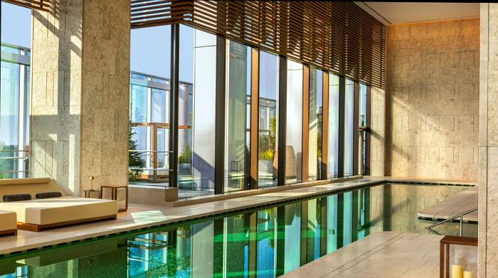 An indoor hotel pool adorned with lush green tiles.