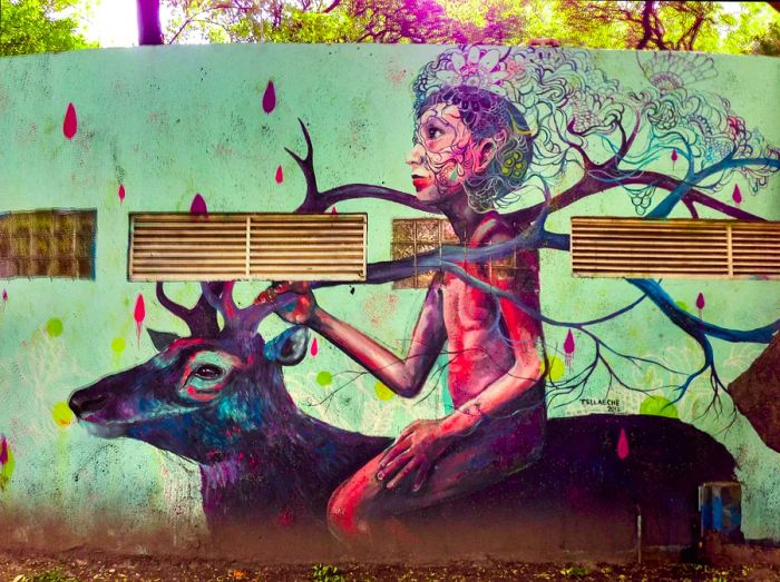 Vibrant street art mural depicting a young person riding an elk on a large wall in the Condesa neighborhood of Mexico City