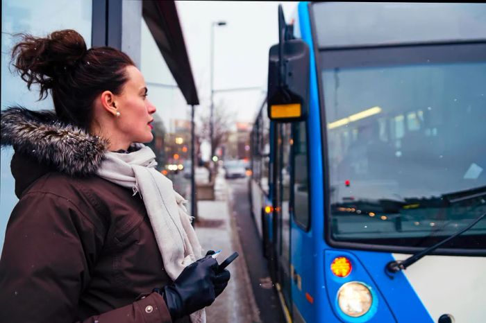 A woman stands waiting for a bus in Montréal, Québec, Canada