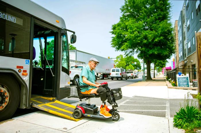 A disabled individual using a mobility scooter exits a bus in the USA.