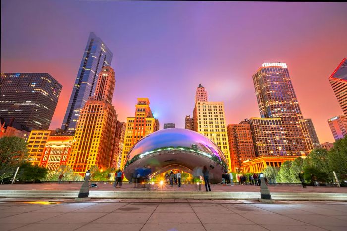 Visitors admire Cloud Gate (“The Bean”) in Millennium Park during the evening, Chicago, Illinois, USA