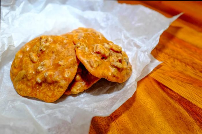 Three golden-brown pralines nestled in pastry paper.