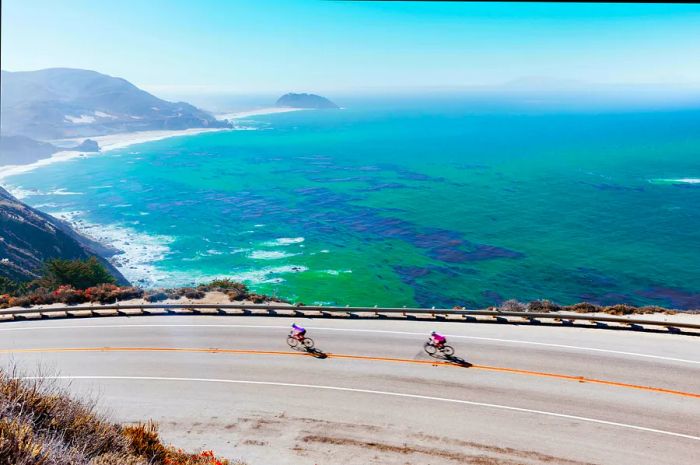 Two cyclists navigate Highway 1 along California's stunning Big Sur coastline.