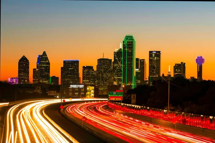 Nighttime traffic on the Tom Landry Freeway with the Dallas skyline in view