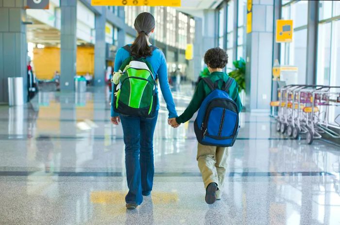 A mother and her son strolling through the Austin airport terminal in Texas.