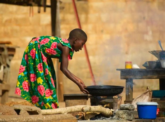 Woman preparing food at a street kitchen in Benin