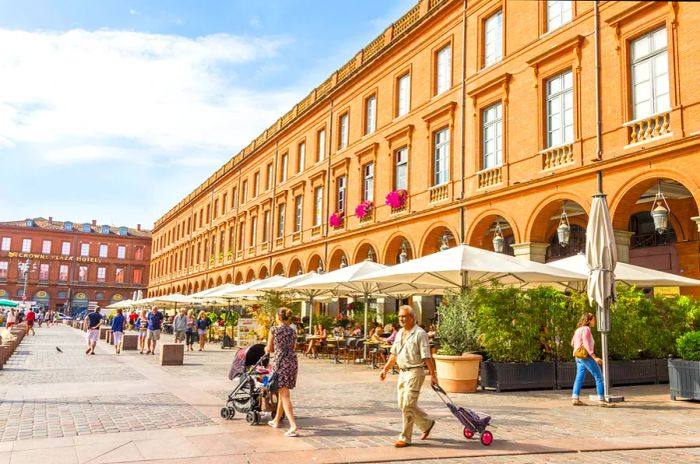 People strolling through the Place du Capitole in Toulouse, France.