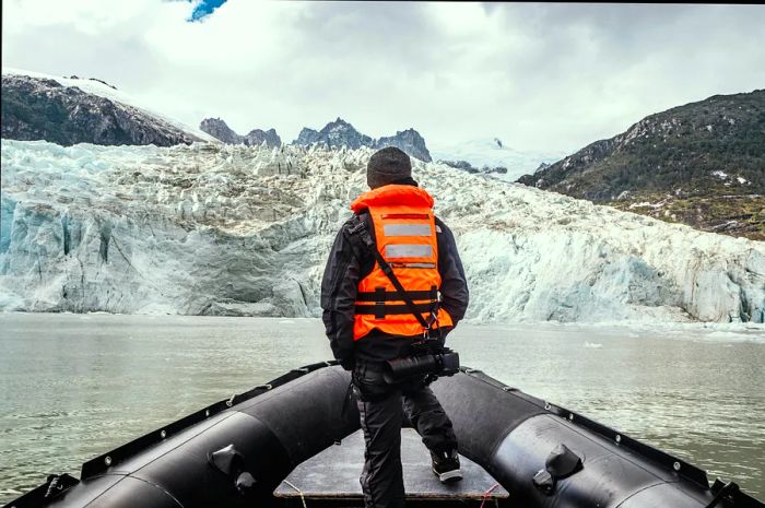 A man gazing at a glacier from a boat